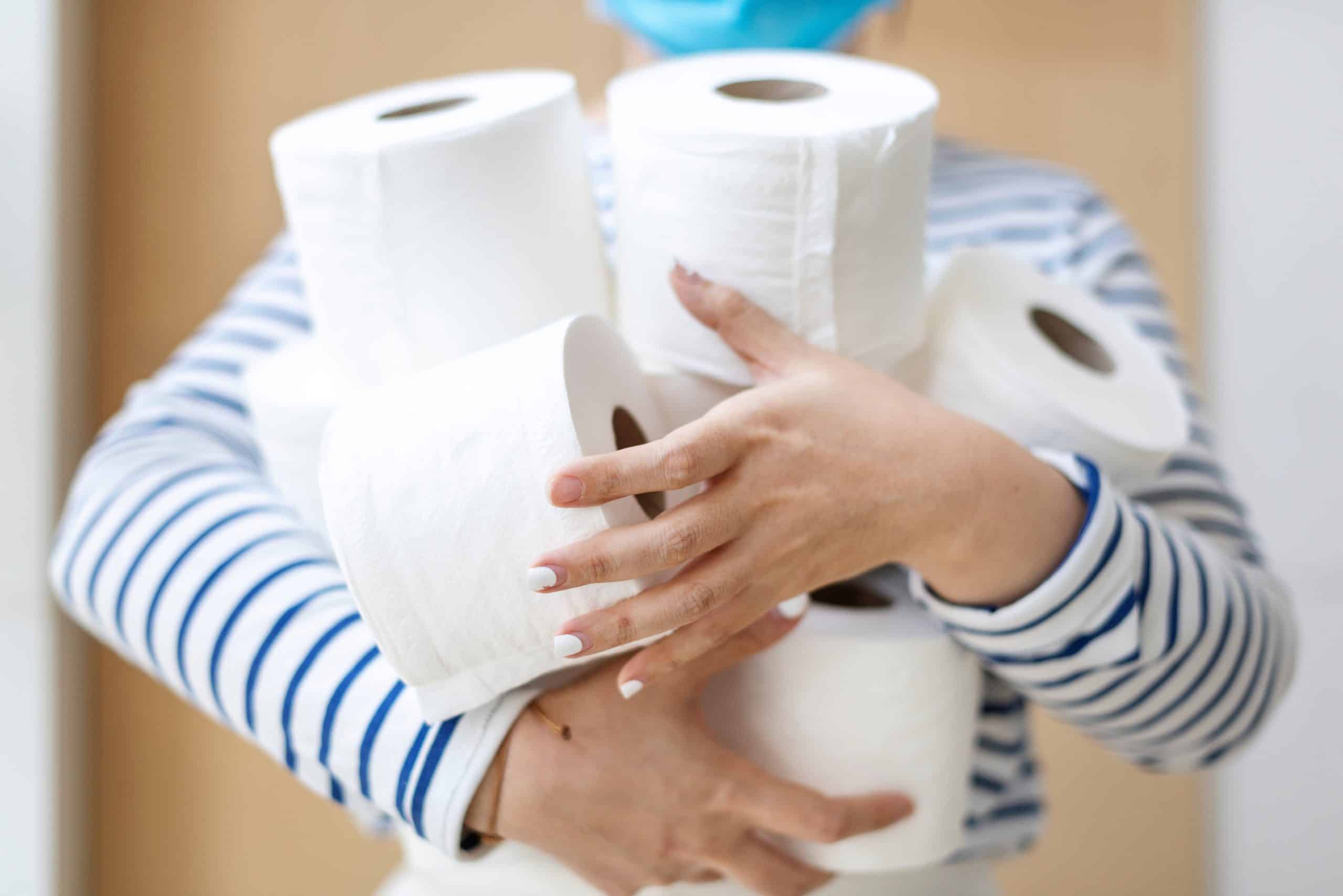 a woman carrying several toilet rolls.
