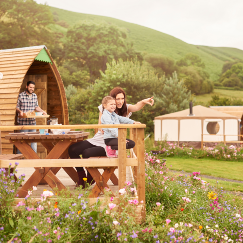 Young family sat outside their yurt in Wales