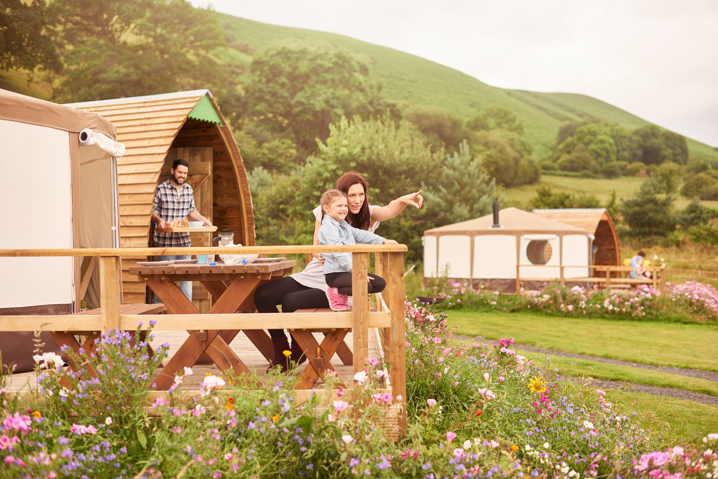 Young family sat outside their yurt in Wales