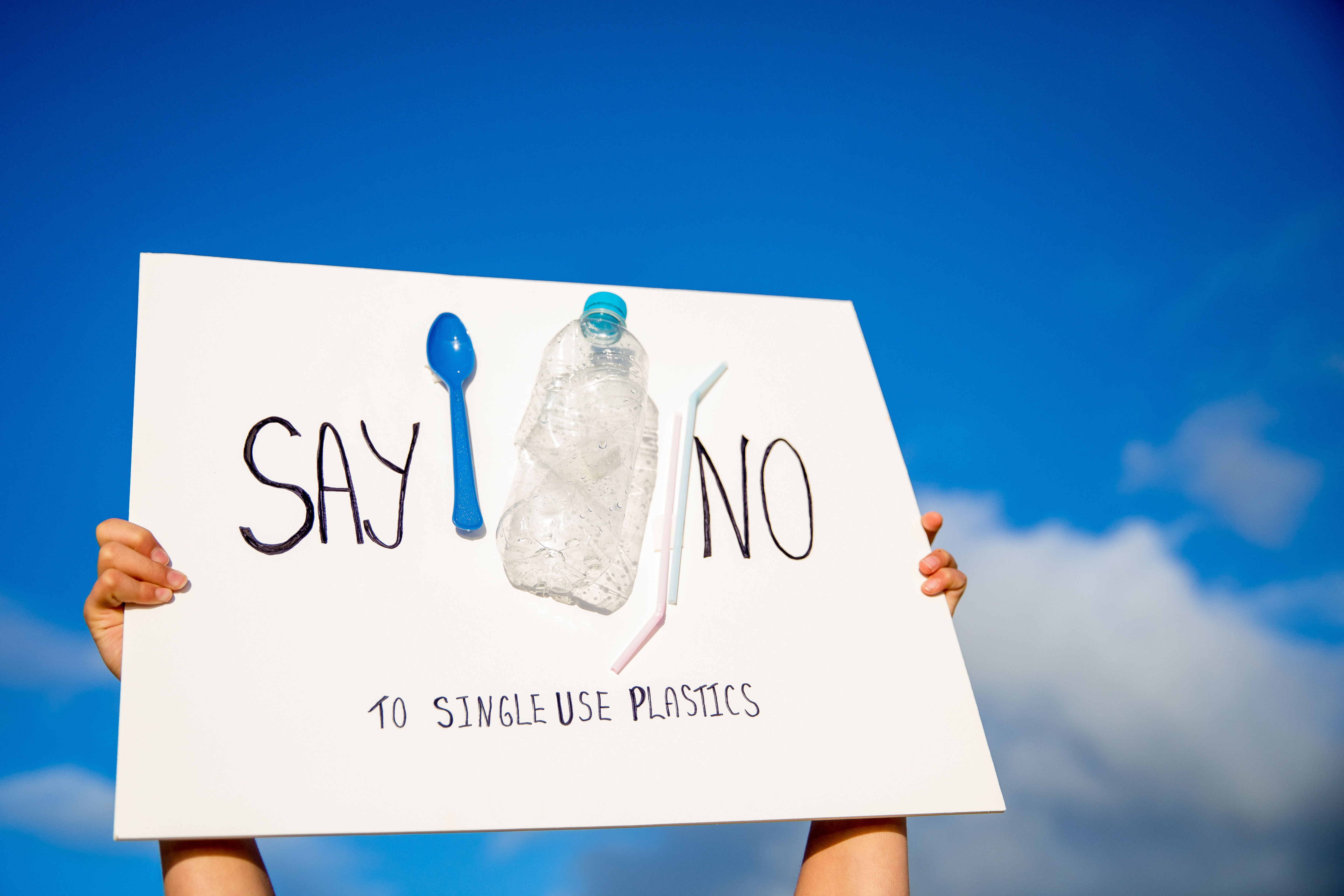 Someone holding a say no to single-use plastics banner